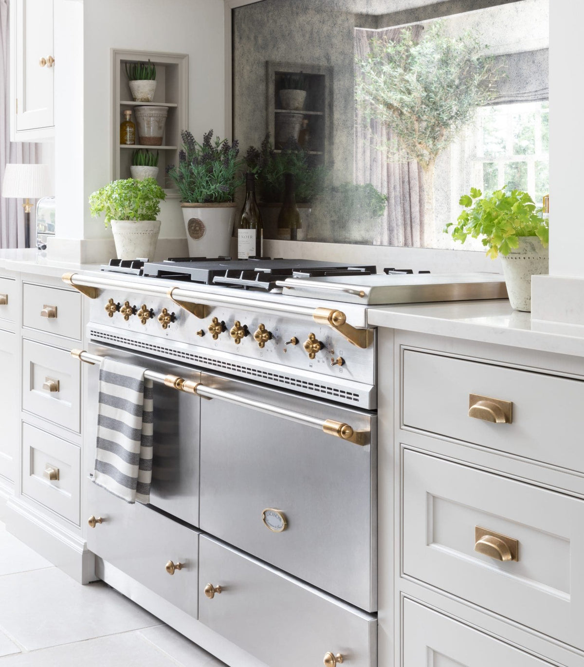 lacanche stainless steel cooker in white kitchen with brass handles